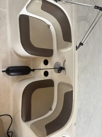 Slide: The Image of The image shows the seating area of a 2016 Bayliner Element boat with brown cushions. - 9