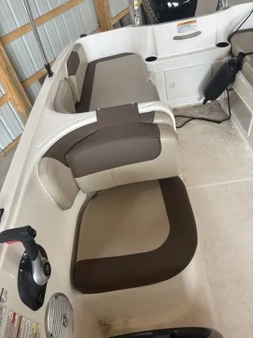 Slide: The Image of Interior view of a 2016 Bayliner Element with beige and brown seats in a storage area. - 10