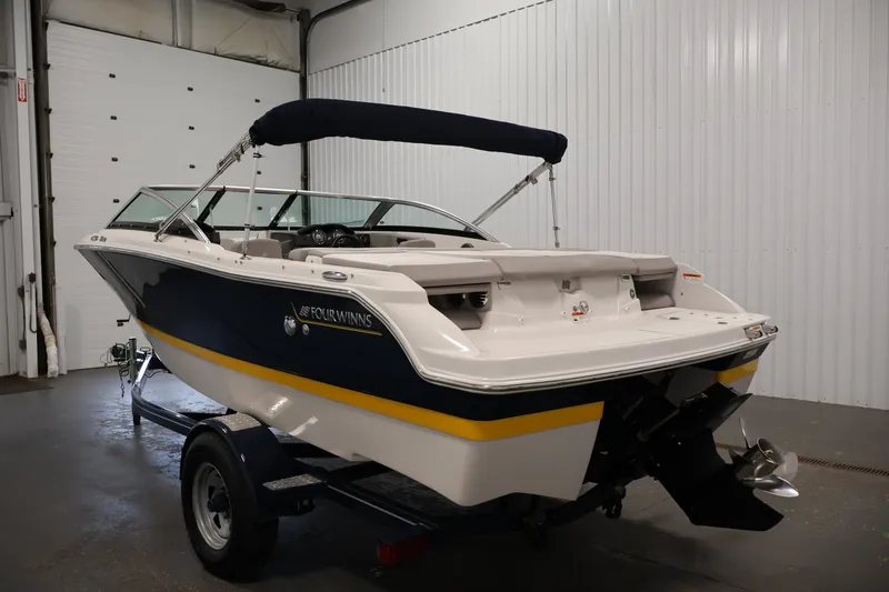 Slide: The Image of 2017 Four Winns H190 boat in a garage, featuring a sleek design and navy blue accents. - 7