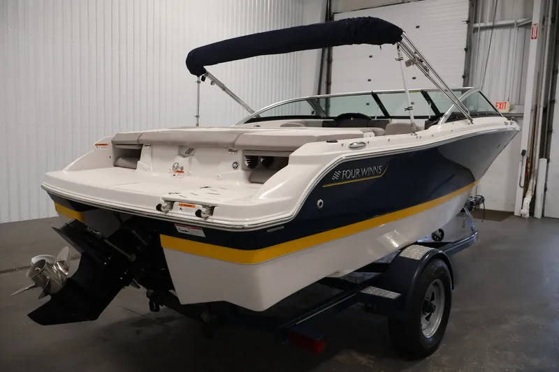 Slide: The Image of 2017 Four Winns H190 boat in a garage, showcasing sleek design and powerful engine. - 5