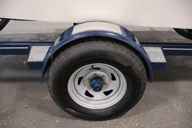Slide: The Image of Trailer wheel of a 2017 Four Winns H190 boat, featuring a blue fender and metal step. - 54