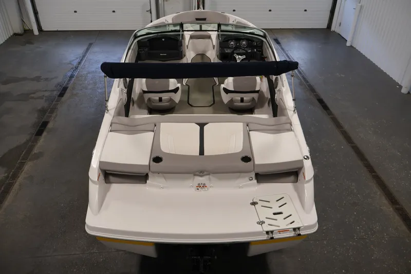 Slide: The Image of 2017 Four Winns H190 boat interior, featuring seating and dashboard, in a garage setting. - 10