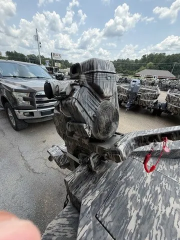 Slide: The Image of A 2026 Havoc 1756 MSTC boat with a camouflaged outboard motor, parked in a lot. - 23
