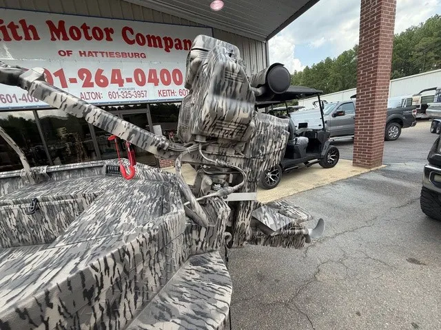 Slide: The Image of A Havoc 1756 MSTC boat with camouflage pattern, parked in front of a building with vehicles in the background. - 10