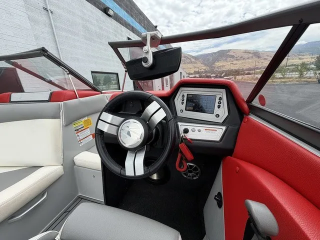 Slide: The Image of The image shows the cockpit of a 2018 Tigé R23 boat with a modern steering wheel and display. - 13