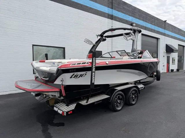 Slide: The Image of A 2018 Tigé R23 boat on a trailer in front of a building. - 3