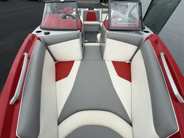 Slide: The Image of The image shows the cockpit of a 2018 Tigé R23 boat with gray and red upholstery. - 18