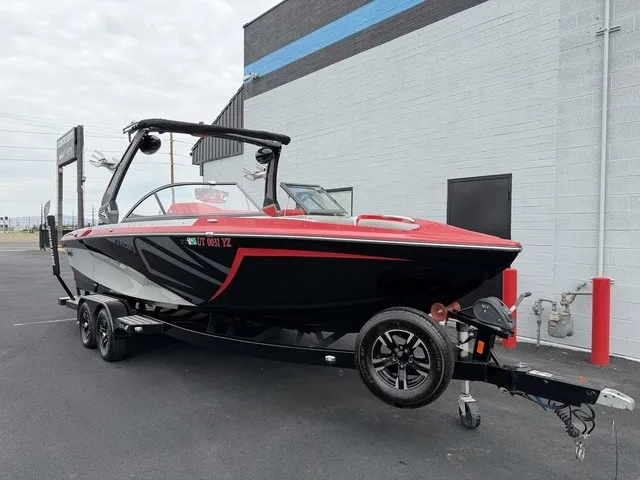 Slide: The Image of A black and red 2018 Tigé R23 boat is on a trailer outside a building. - 2