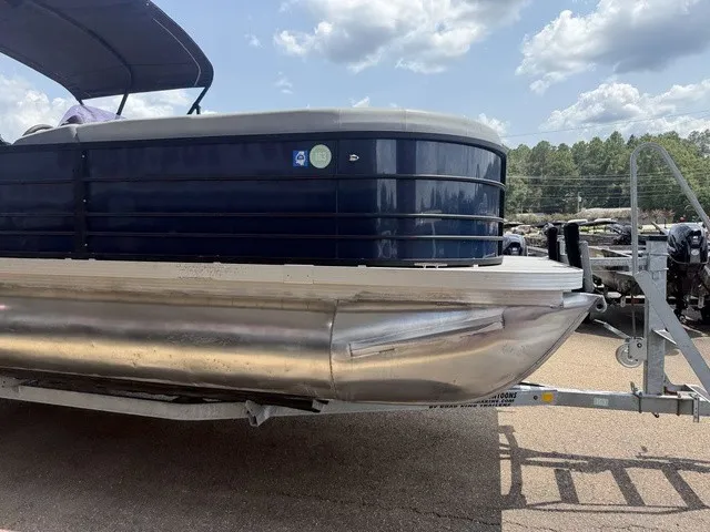 Slide: The Image of A 2022 Veranda Vista View 22RC pontoon boat on a trailer, surrounded by trees. - 5