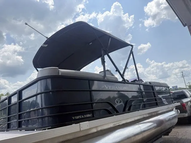 Slide: The Image of A 2022 Veranda Vista View 22RC pontoon boat with a black bimini top under a cloudy sky. - 9