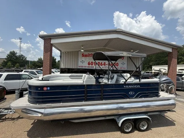 Slide: The Image of A blue 2022 Veranda Vista View 22RC pontoon boat on a trailer in front of a building. - 1