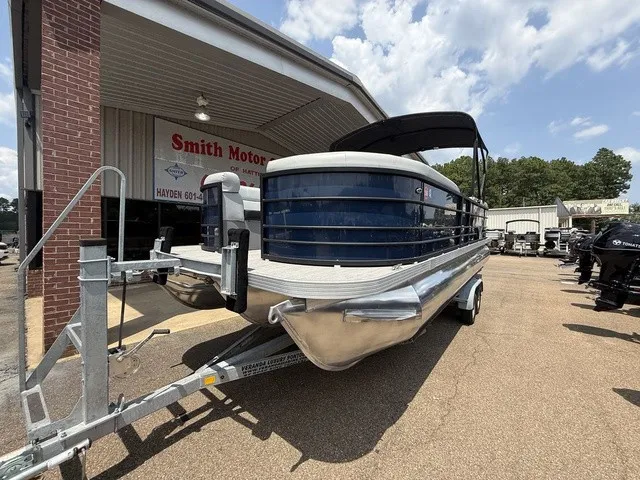 Slide: The Image of A 2022 Veranda Vista View 22RC pontoon boat on a trailer in front of a building. - 2