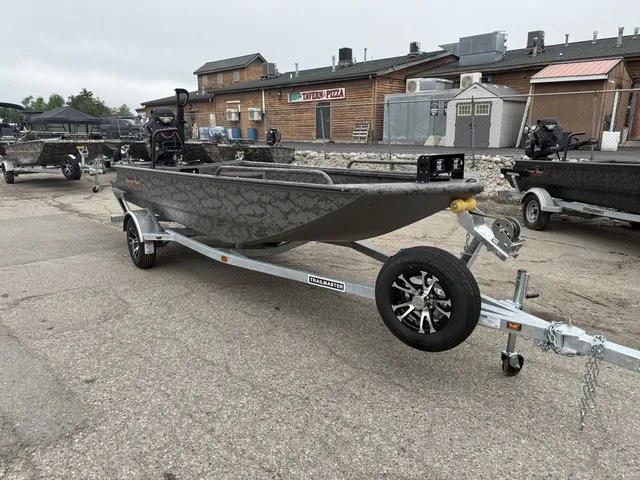 Slide: The Image of A GATOR-TAIL GB 1750 Mid Savage boat on a trailer, parked in a lot. - 2