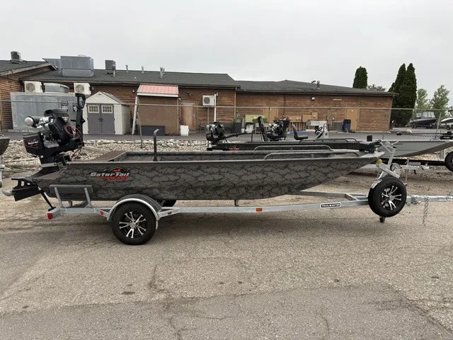 Slide: The Image of A GATOR-TAIL GB 1750 Mid Savage boat on a trailer, parked on a paved lot. - 1