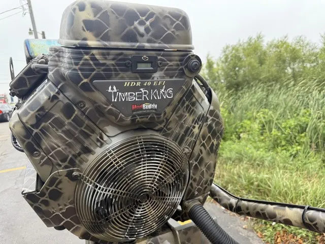 Slide: The Image of Close-up of a boat engine with camouflage pattern and "Timber King" branding. - 9