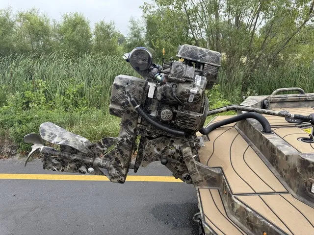 Slide: The Image of A camouflaged outboard motor on a boat, surrounded by lush greenery. - 8