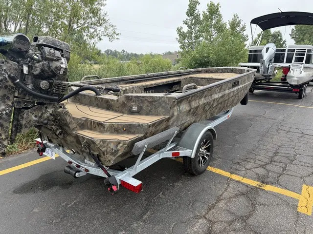 Slide: The Image of An Excel 175 SWF4 Legacy boat on a trailer, surrounded by trees and another boat. - 3