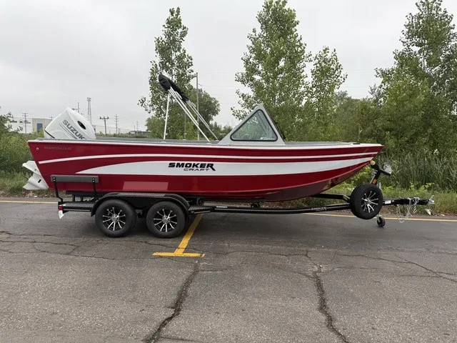 The Image of A red Smoker Craft Phantom 20 X2 boat from 2027 on a trailer in a parking lot. - 1