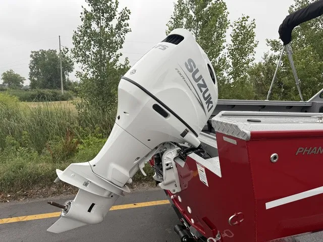 Slide: The Image of A red boat with a white Suzuki outboard motor, surrounded by trees and a road. - 9