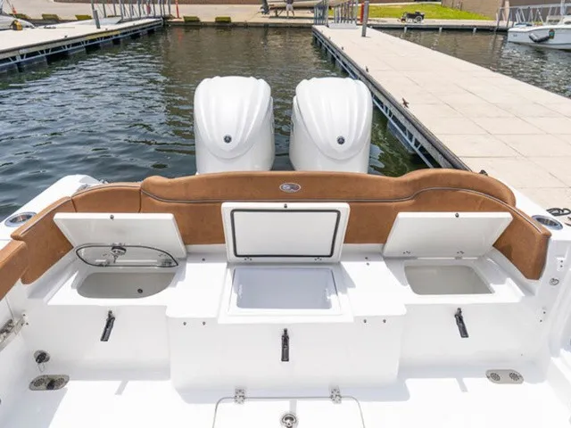 Slide: The Image of The image shows the stern of a Sea Hunt Ultra 305 FS boat with twin engines. - 9