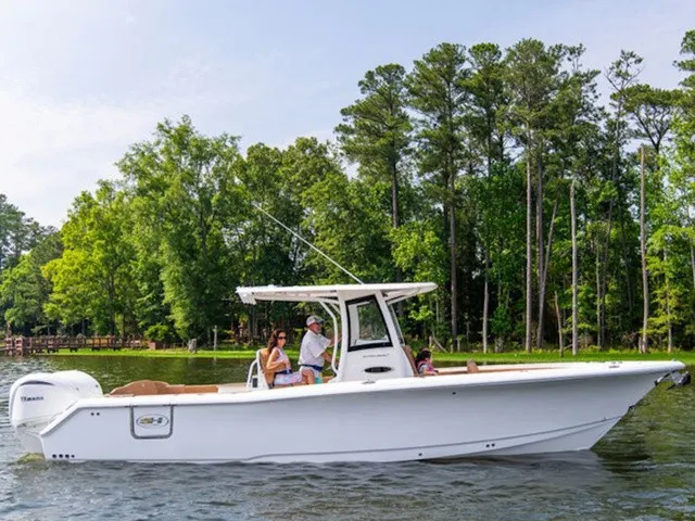 Slide: The Image of A white boat cruising on calm water, surrounded by trees. People are seated on board. - 2