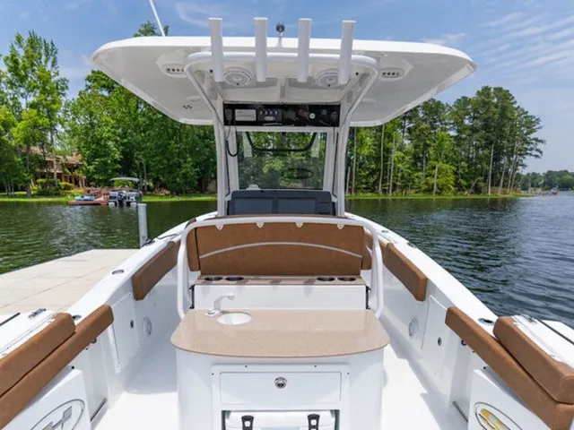 Slide: The Image of The image shows a 2027 Sea Hunt Ultra 305 FS boat on a calm lake. - 8
