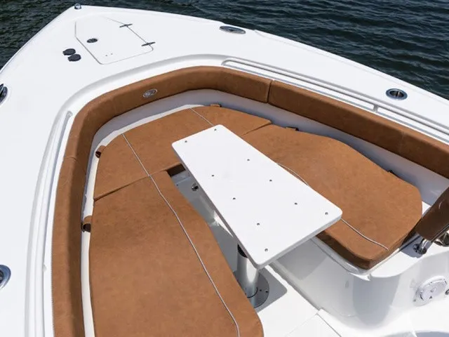 Slide: The Image of The image shows the bow area of a Sea Hunt Ultra 305 FS with brown cushions and a white table. - 7