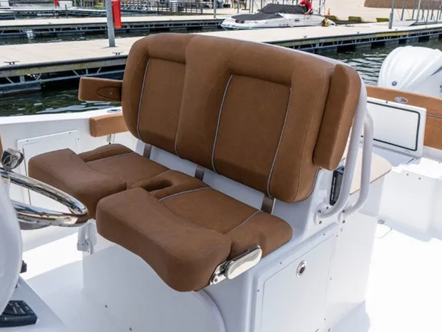 Slide: The Image of Brown cushioned double seats on a boat, with a steering wheel nearby, in a marina. - 10