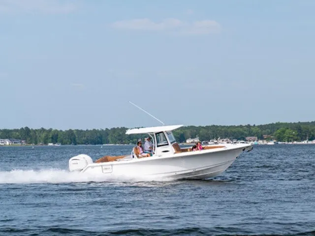Slide: The Image of A Sea Hunt Ultra 305 FS boat speeds across the water, with people on board. - 3