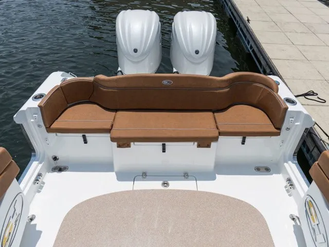 Slide: The Image of The image shows the stern of a Sea Hunt Ultra 305 FS boat with brown seating and two engines. - 6