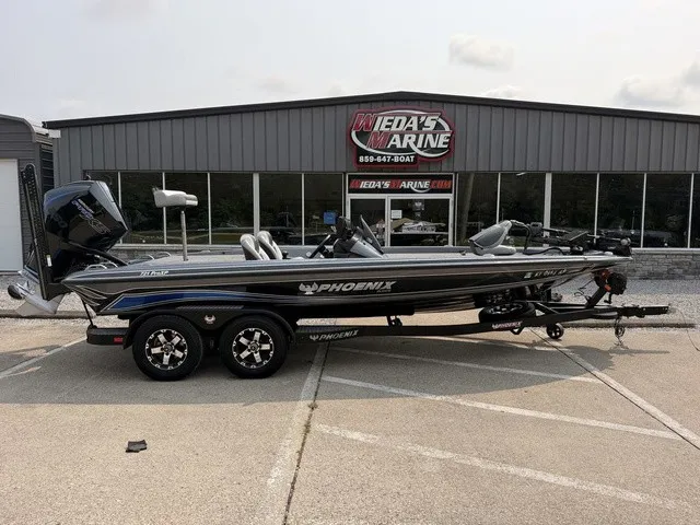 The Image of A 2022 Phoenix 721 ProXP bass boat on a trailer in front of a building labeled "Wieda's Marine." - 1