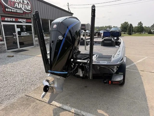 Slide: The Image of A 2022 Phoenix 721 ProXP boat with a powerful outboard motor, parked in a lot. - 2