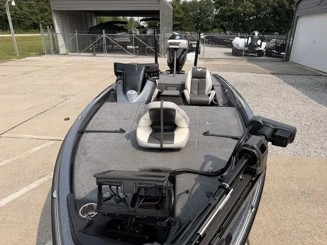 Slide: The Image of A gray fishing boat with two seats and a motor, parked on a concrete lot. - 14