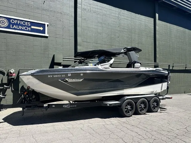 The Image of A 2022 Nautique Super Air Nautique G23 Paragon on a trailer, parked in front of a building. - 1