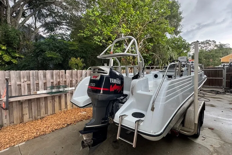 Slide: The Image of 1997 Citation Seapro 220 Aquadek boat with Yamaha 150 engine, parked outdoors. - 2