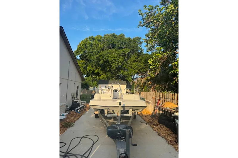 Slide: The Image of 1997 Citation Seapro 220 Aquadek boat parked on a driveway, surrounded by trees. - 3