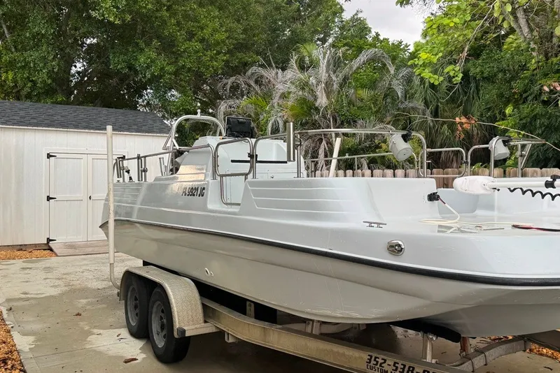 Slide: The Image of 1997 Citation Seapro 220 Aquadek boat on trailer, parked near a shed and trees. - 1