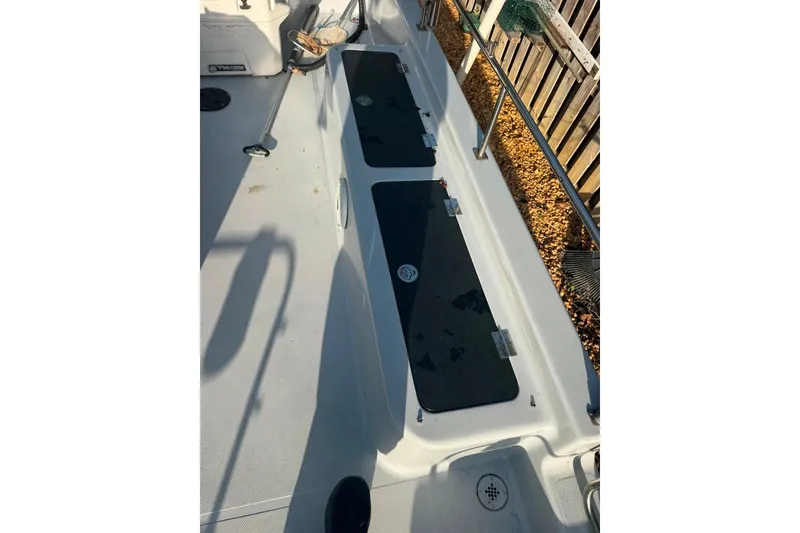 Slide: The Image of 1997 Citation Seapro 220 Aquadek boat deck with storage compartments and railing. - 6