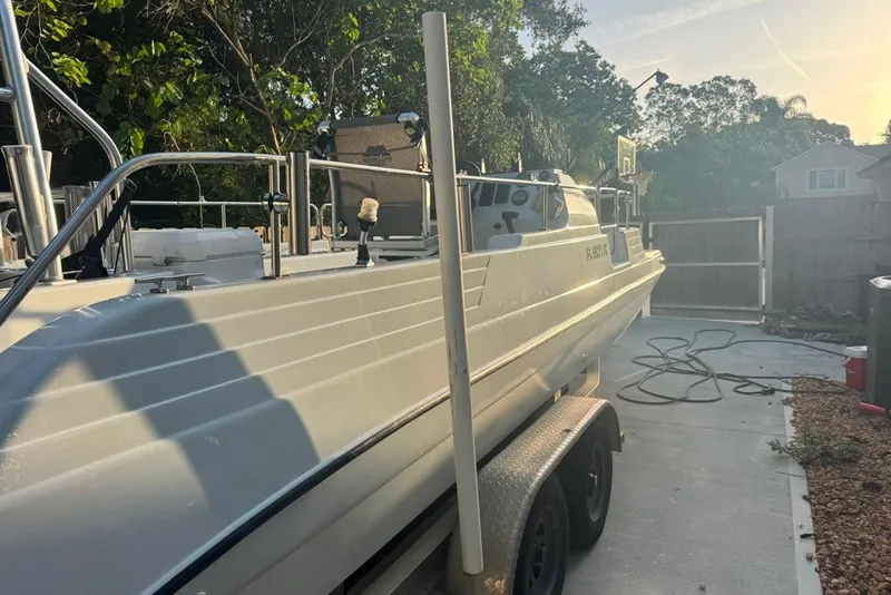 Slide: The Image of 1997 Citation Seapro 220 Aquadek boat on trailer in driveway, surrounded by trees. - 5