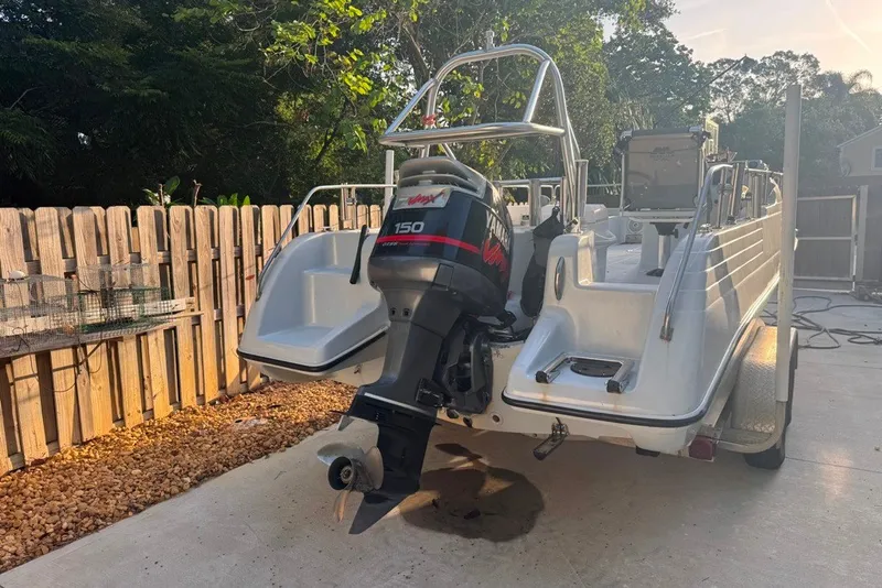 Slide: The Image of 1997 Citation Seapro 220 Aquadek boat with Yamaha 150 outboard motor, parked on a driveway. - 4