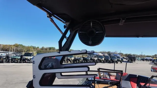 Slide: The Image of An ATX boat with modern speakers and mounts, parked outdoors, surrounded by vehicles. - 15