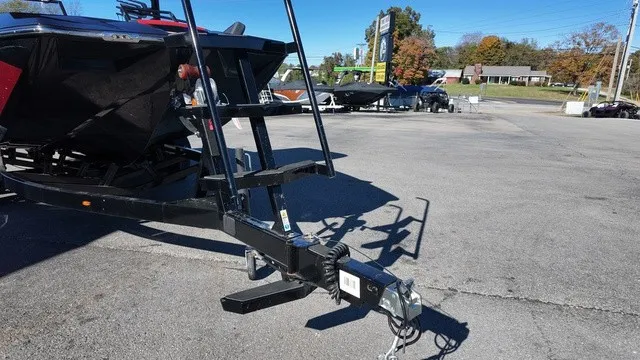 Slide: The Image of A black boat trailer with a hitch is parked in a lot. - 5