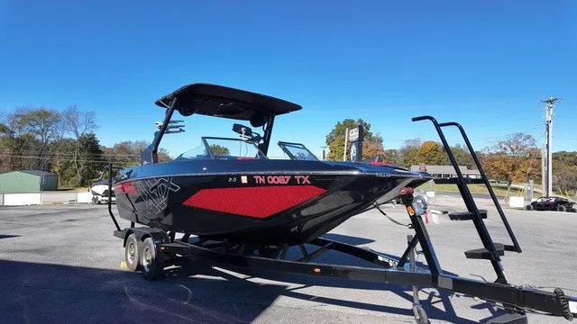 Slide: The Image of A black ATX boat, model 22 S, year 2023, is on a trailer in a parking lot. - 4