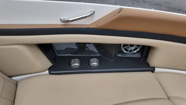 Slide: The Image of The 2015 Sea Ray SLX 250 features beige upholstery with cup holders and a speaker. - 27