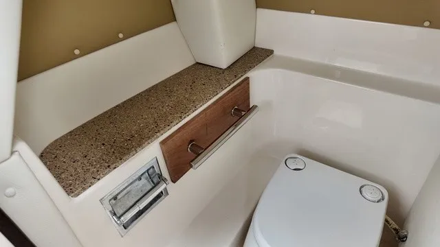 Slide: The Image of Interior of a 2015 Sea Ray SLX 250 featuring a toilet and a sink. - 21