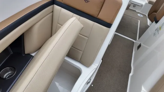 Slide: The Image of The 2015 Sea Ray SLX 250 interior features comfortable, cushioned seating in beige and brown. - 29