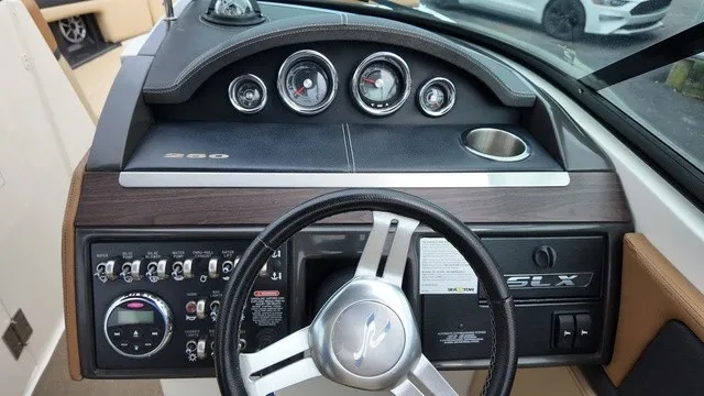 Slide: The Image of The image shows the dashboard of a 2015 Sea Ray SLX 250 boat with multiple gauges and a steering wheel. - 23