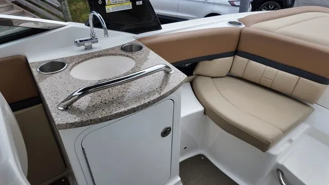 Slide: The Image of The image shows the interior of a 2015 Sea Ray SLX 250 boat with a small kitchenette. - 16