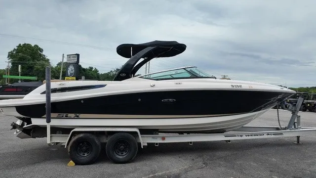 Slide: The Image of A 2015 Sea Ray SLX 250 boat on a trailer, featuring a black hull and white deck. - 6