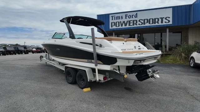Slide: The Image of A 2015 Sea Ray SLX 250 boat on a trailer in front of a store named Tims Ford Powersports. - 3
